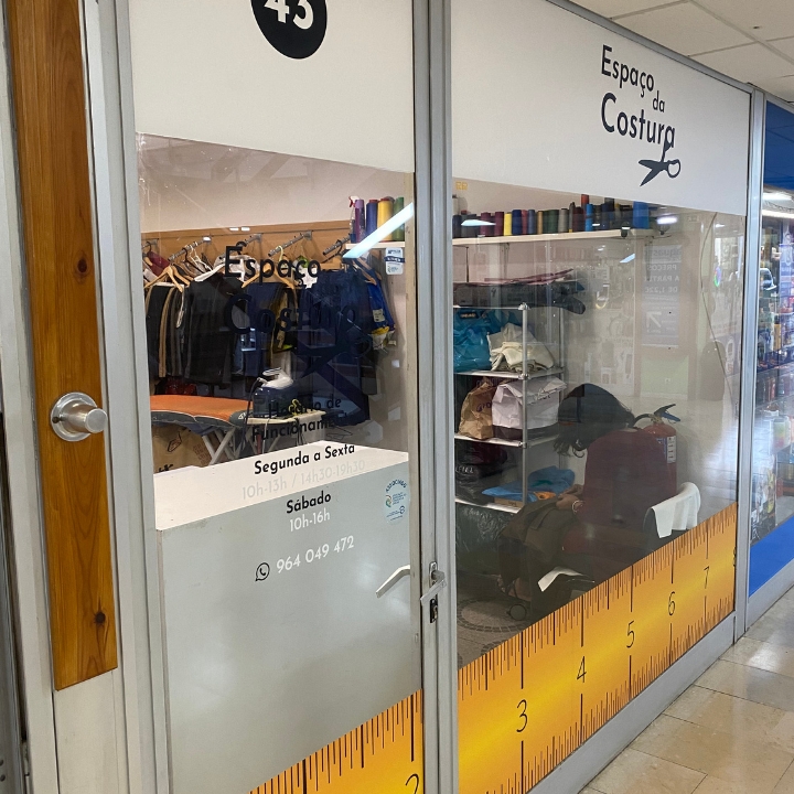 Interior da loja Espaço da Costura com roupas e materiais de costura